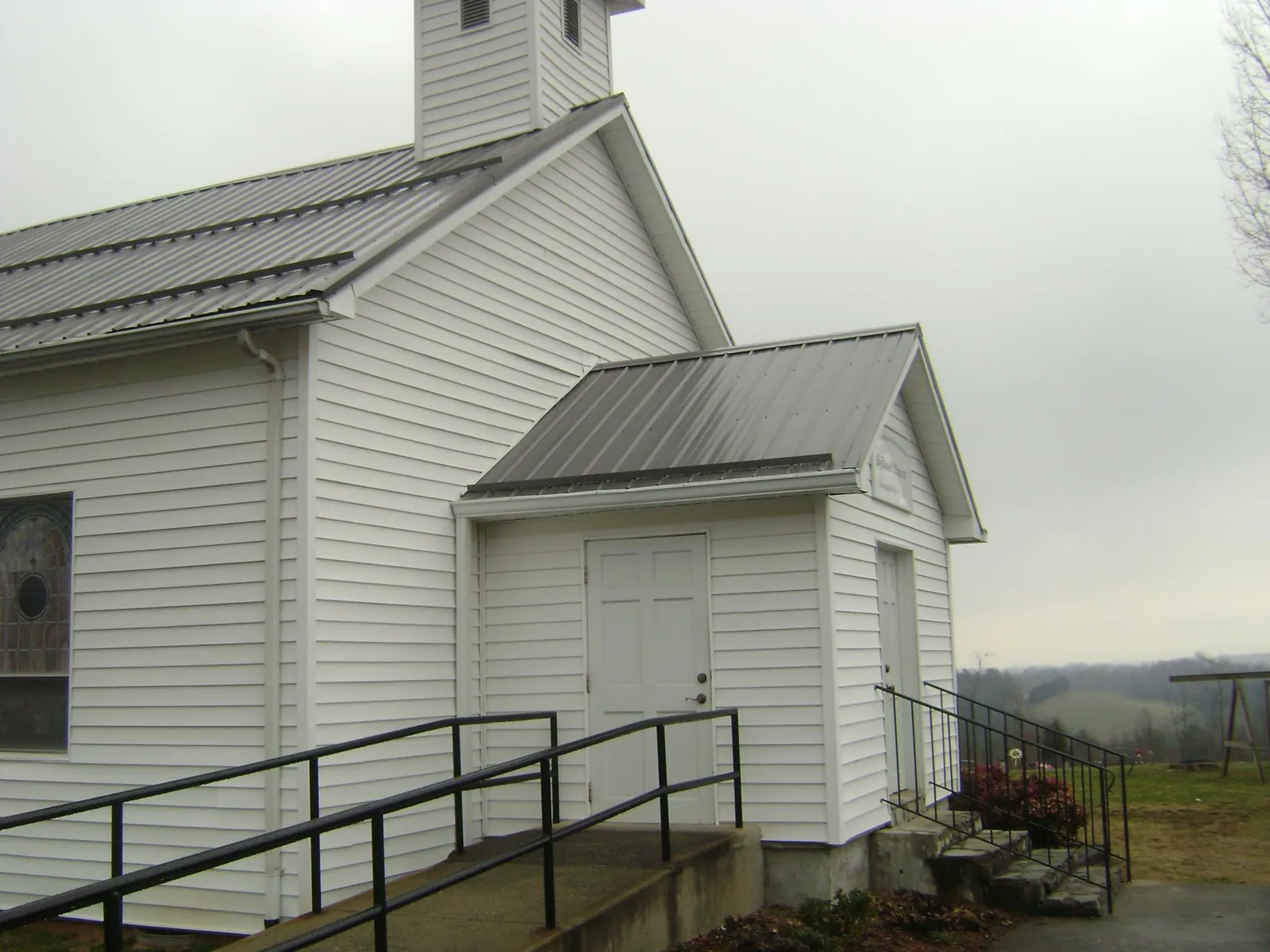 Gray metal roof on a white clapboard church with a steeple in Stillwater
